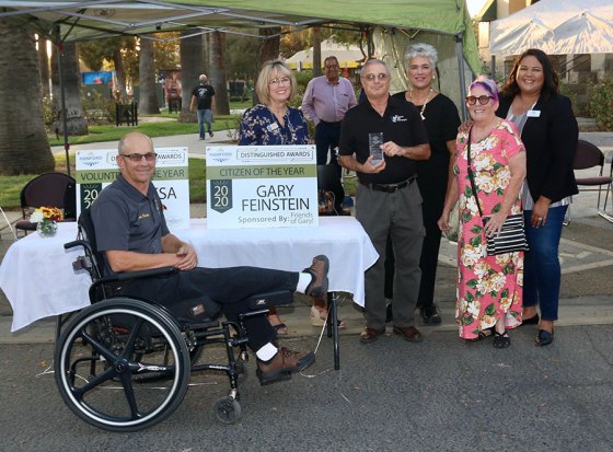 Well known Kings County photographer named Hanford Chamber's Citizen of the Year Gary Feinstein, holding trophy, during the Hanford Chamber of Commerce awards presentation with members of the Hanford Chamber and fiance Calvie Clement.